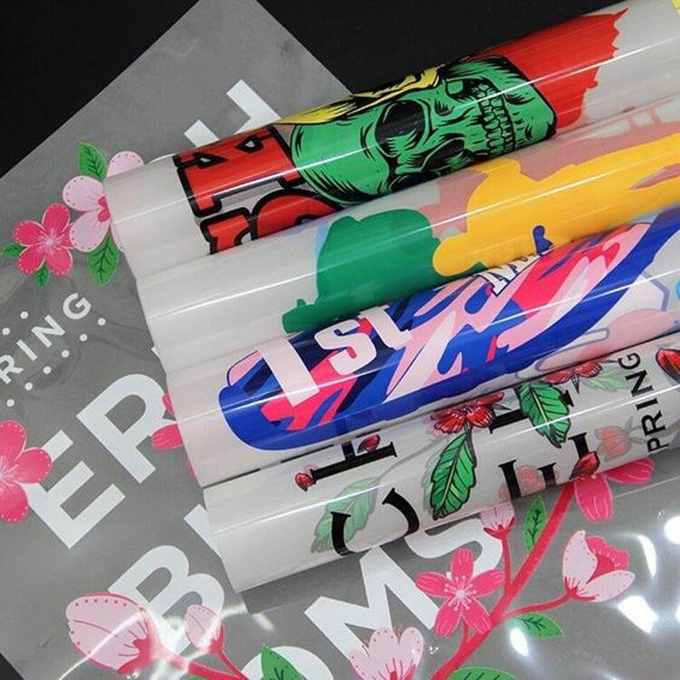 Colorful tubes with graphic designs on a gray background with floral elements