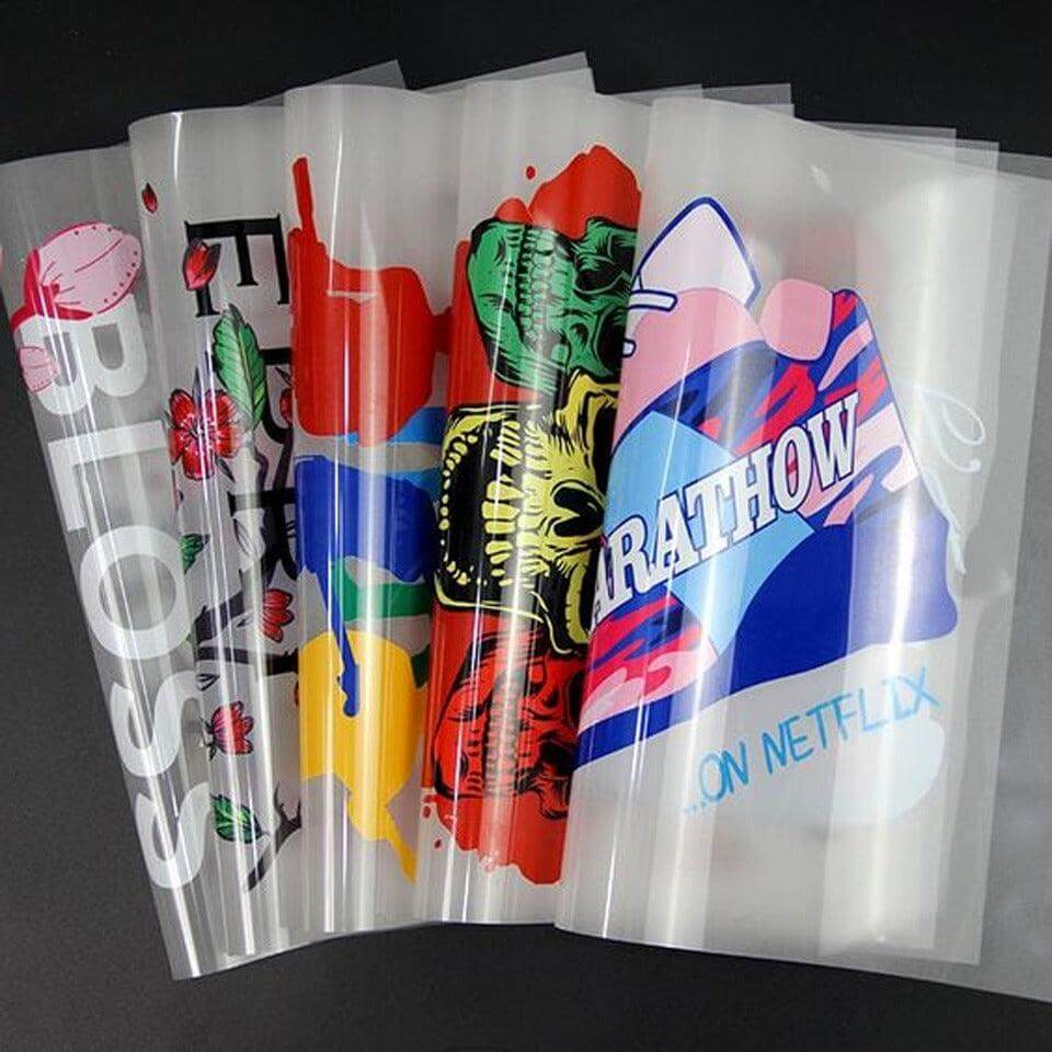 Clear plastic bags with colorful designs and text on a black background